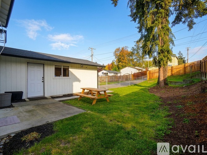 A backyard with a picnic table and a shed.