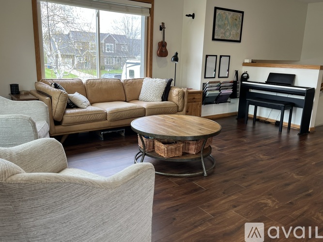 A living room with a tan couch and a white chair.