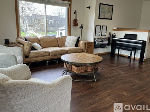 A living room with a tan couch and a white chair.