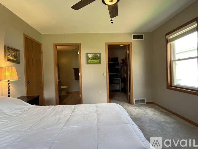 A bedroom with a large bed and a ceiling fan.
