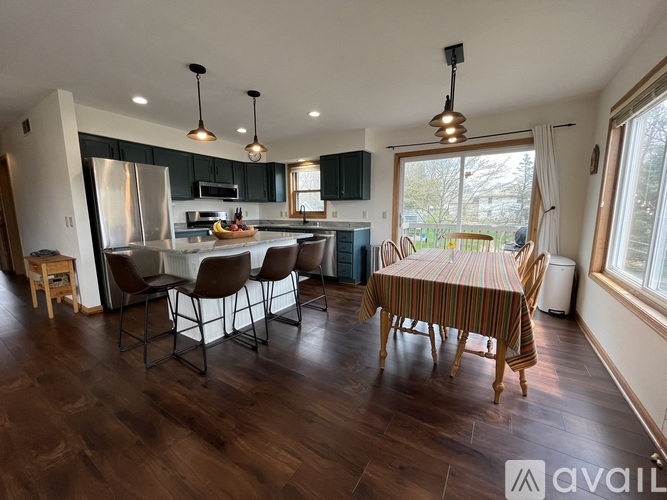 A kitchen with a dining table and chairs.