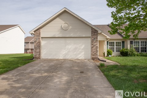 A house with a garage door and a driveway.