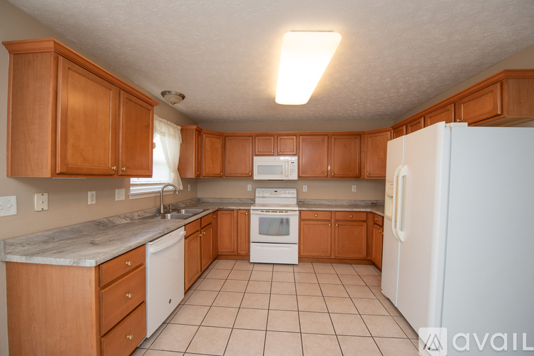 A kitchen with wooden cabinets and white appliances.
