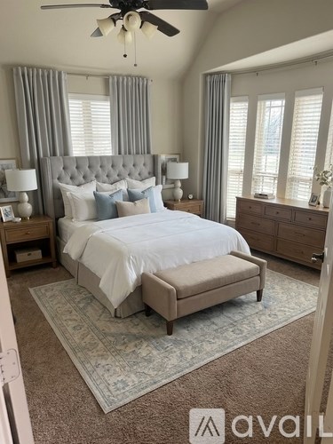 A bedroom with a large bed and a ceiling fan.