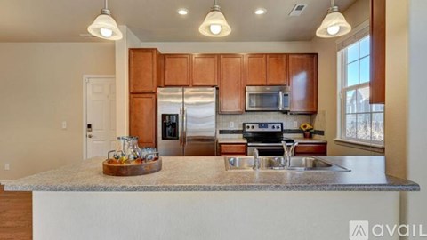 A kitchen with wooden cabinets and a granite countertop.