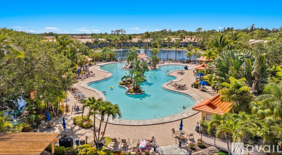A resort with a large pool and a smaller pool in the middle of it.