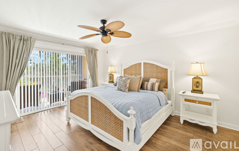 A bedroom with a large bed and a ceiling fan.