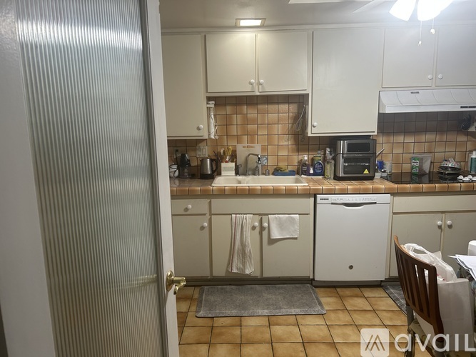 A kitchen with white cabinets and a white dishwasher.