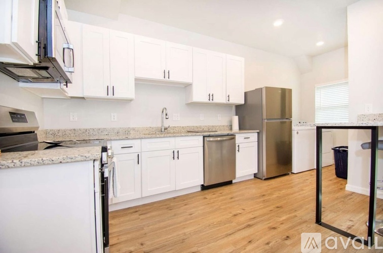A kitchen with white cabinets and a granite countertop.
