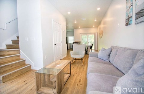 A living room with a grey couch and a glass coffee table.