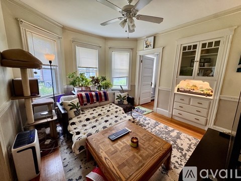 A living room with a wooden coffee table and a sofa with a patterned cushion.
