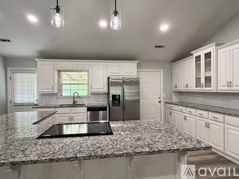 A kitchen with granite countertops and stainless steel appliances.
