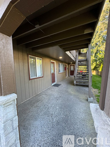 A covered walkway with a stone pillar on the left and a staircase on the right.