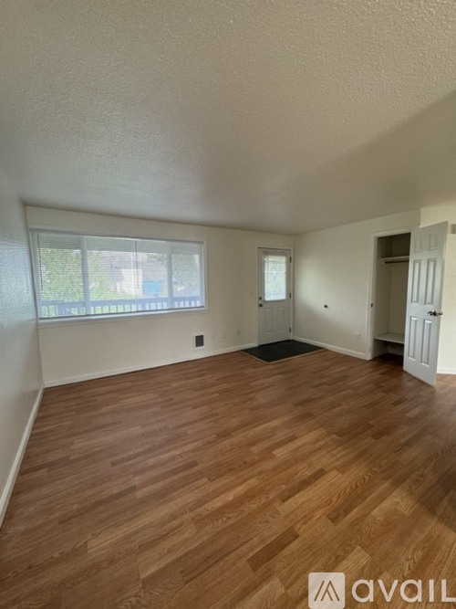 A room with wooden flooring and a window.