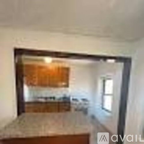 A kitchen with a wooden cabinet and a window.