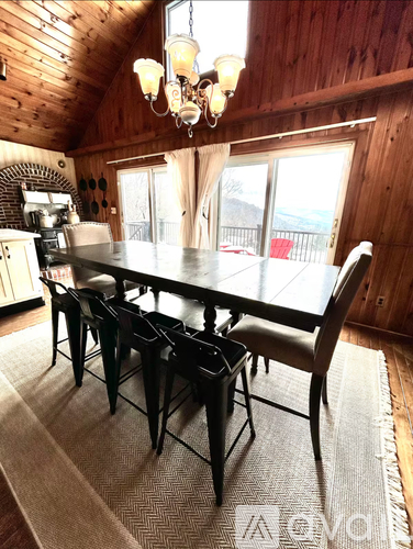 A wooden dining room with a table and chairs.