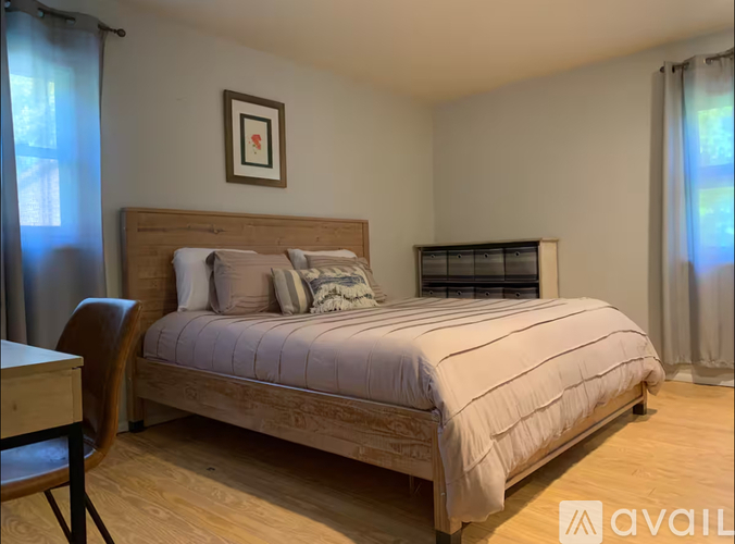 A bedroom with a large bed and a wooden headboard.