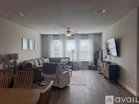 A living room with a grey couch and a wooden table.