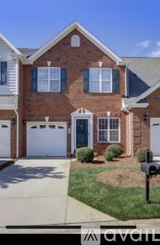A brick house with a white garage door and a mailbox.