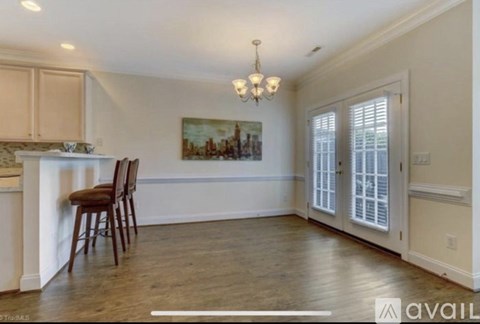 A dining room with a wooden table and chairs.
