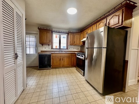 A kitchen with wooden cabinets and a stainless steel refrigerator.