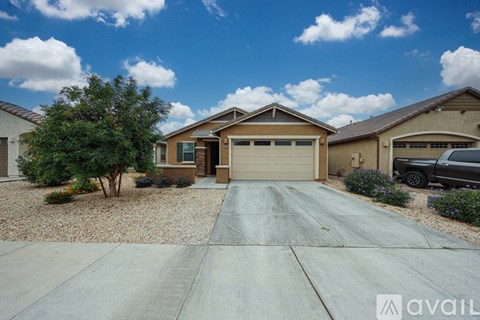A house with a driveway and a tree in front of it.