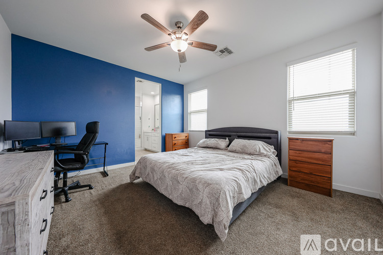 A bedroom with a bed, desk, and chair.