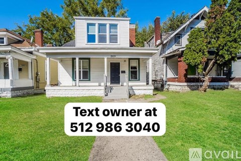 A house with a sign that says "Text owner at 512 986 3040".