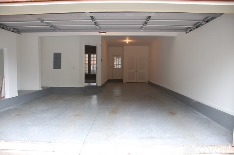 A spacious garage with a white floor and walls, and a red roof.