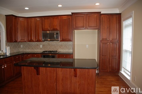 A kitchen with wooden cabinets and a black countertop.
