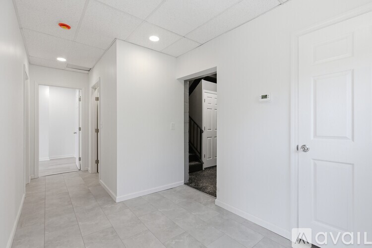 A staircase with a black railing and a white door at the top.