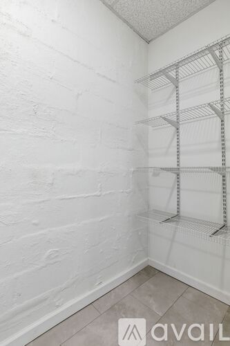 A room with white walls and wooden flooring, featuring a door and a window.