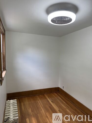 A room with a wooden floor and a ceiling light.
