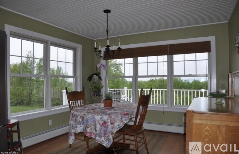 A dining room with a table and chairs and a chandelier.