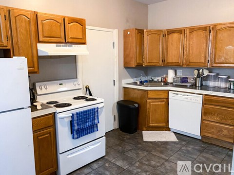 A kitchen with wooden cabinets and a white stove top oven.