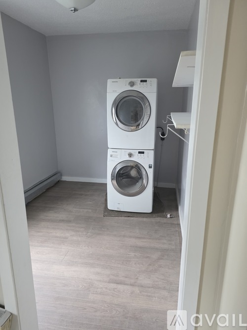A laundry room with a washer and dryer stacked on top of each other.