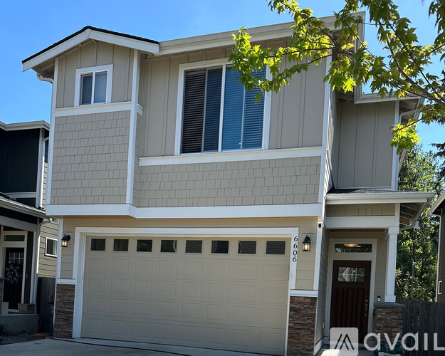 A two-story house with a garage is available for sale.