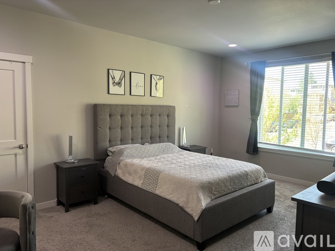 A bedroom with a large bed and a grey headboard.