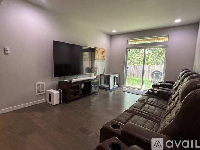 A living room with a brown couch and a flat screen TV.