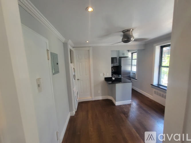 A room with a kitchen island and a ceiling fan.