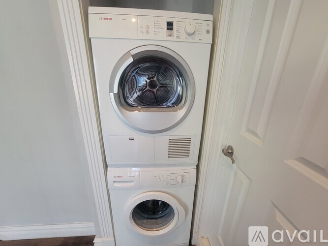 A white front load washing machine with a black door in the middle.