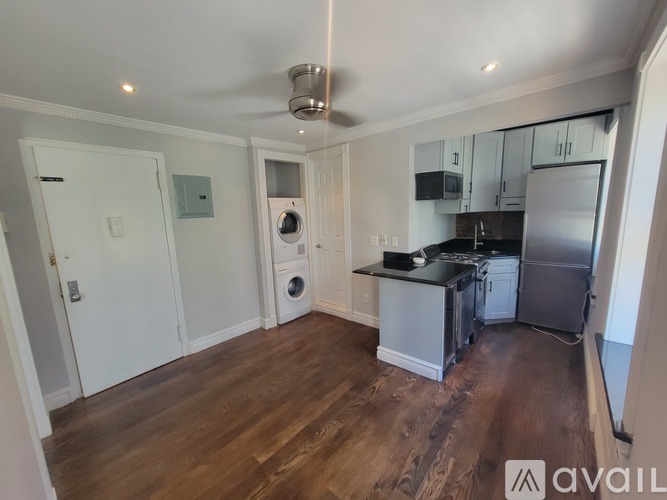 A kitchen with a refrigerator, microwave, and oven.