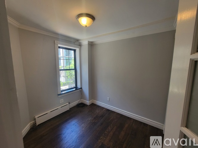 A room with a window and a radiator on the floor.
