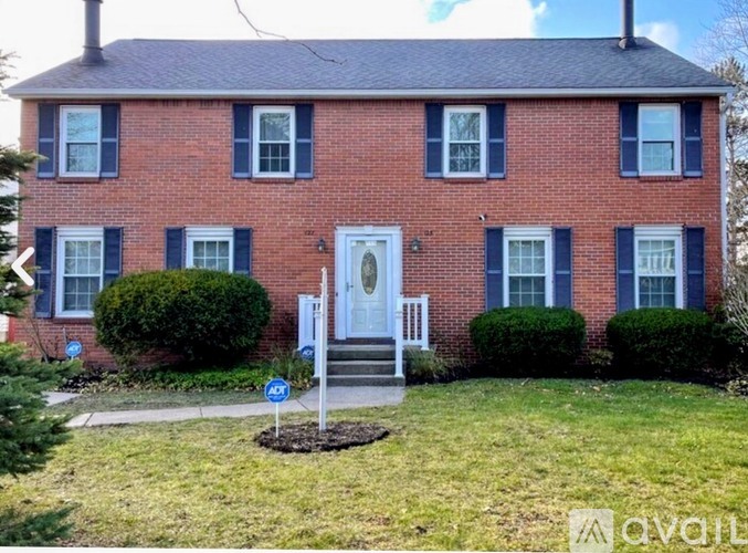 A red brick house with a white door and a sign that says 45.