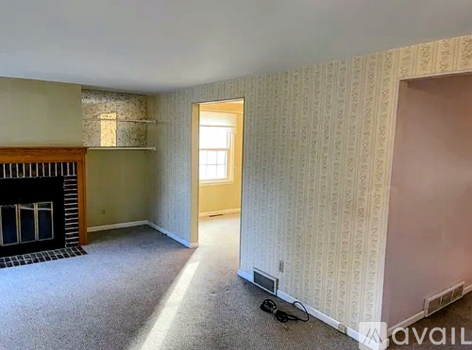 A room with a fireplace and a door leading to another room.