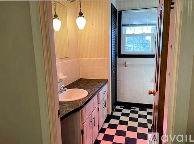 A bathroom with a checkered floor and a window.