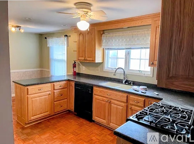 A kitchen with wooden cabinets and a black stove top.
