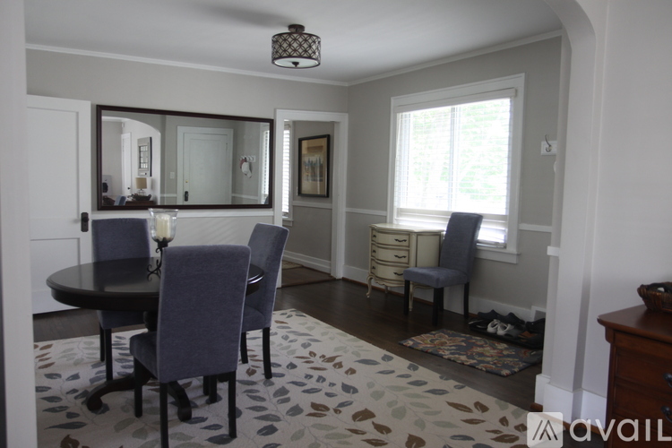 A dining room with a round table and chairs.