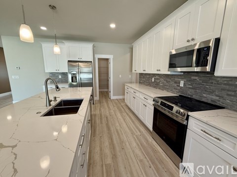 A kitchen with white cabinets and a marble countertop.