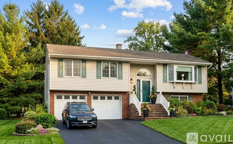 A house with a green door and a black car in front.